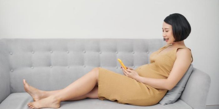 Pregnant20woman20using20phone20on20couch-eGjhhN-rss