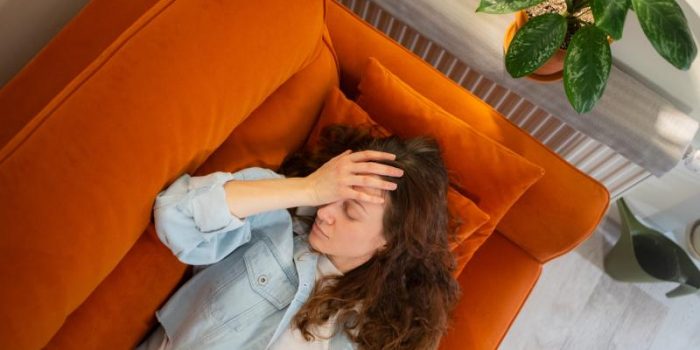 Woman20with20a20headache20on20orange20sofa-POoTew-rss